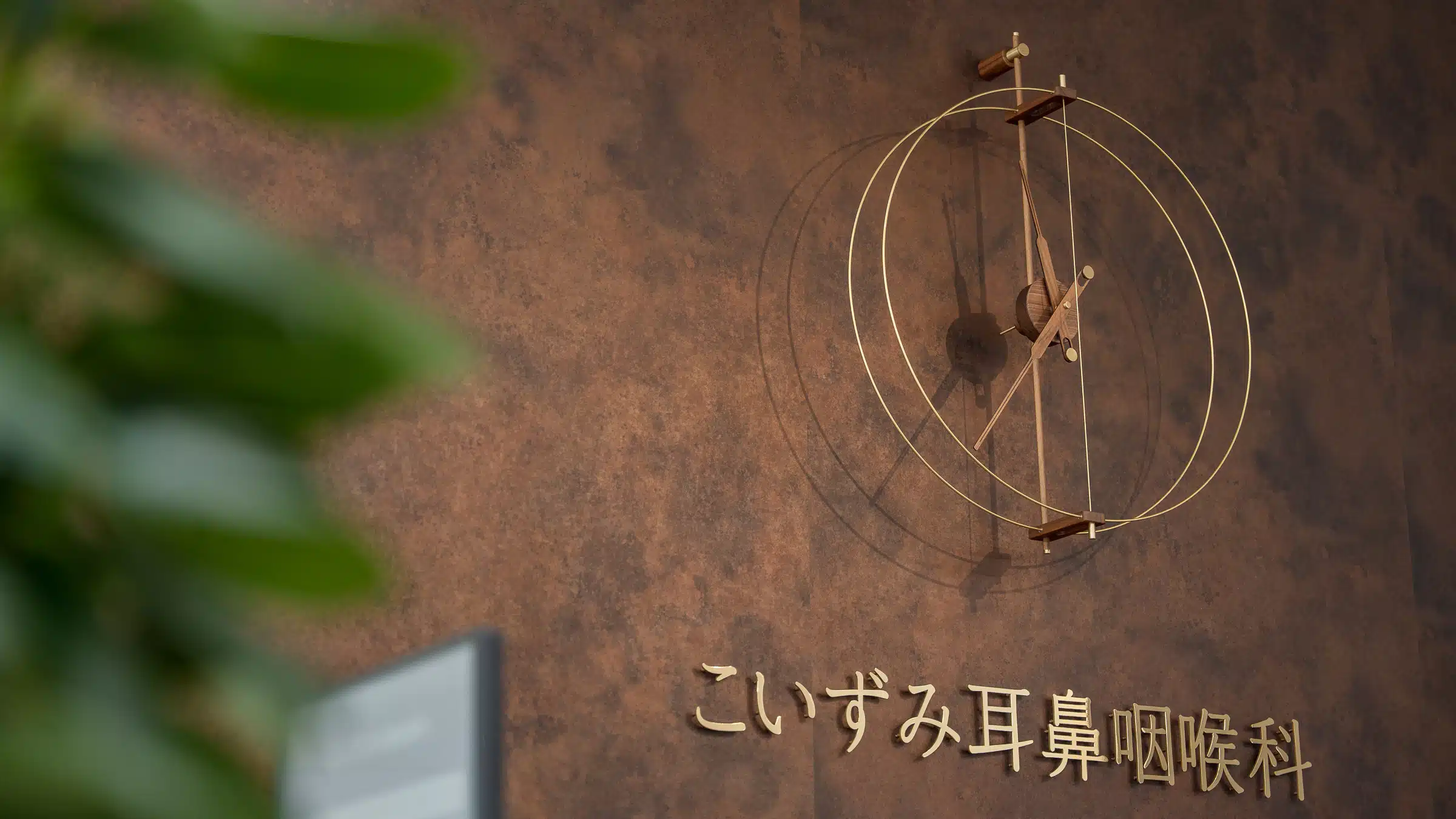 院内の壁面に設置された、こいずみ耳鼻咽喉科のロゴサイン