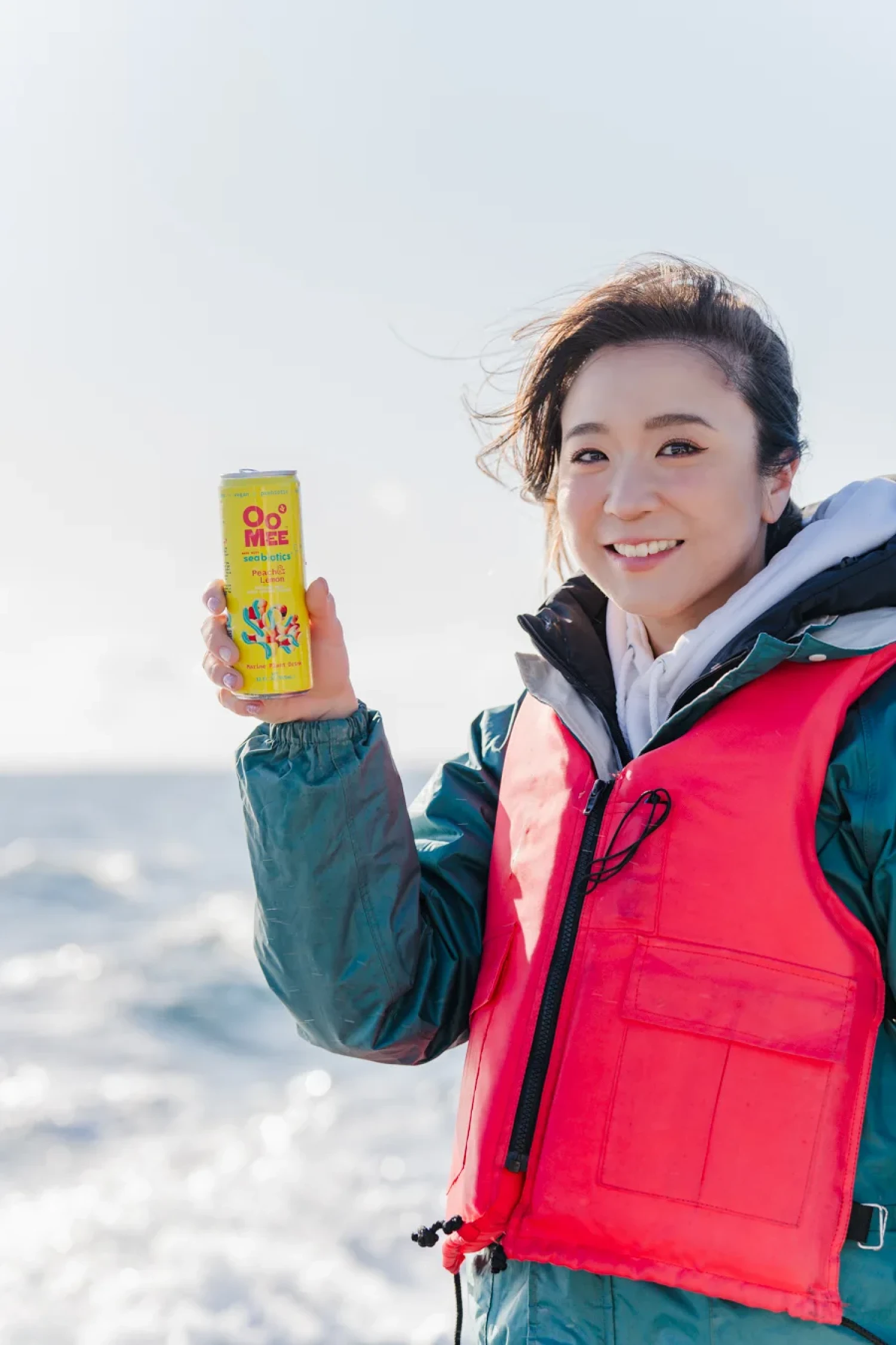 宮城県の海で海藻飲料「OoMee」を持つ三木アリッサ（Alissa Miky）