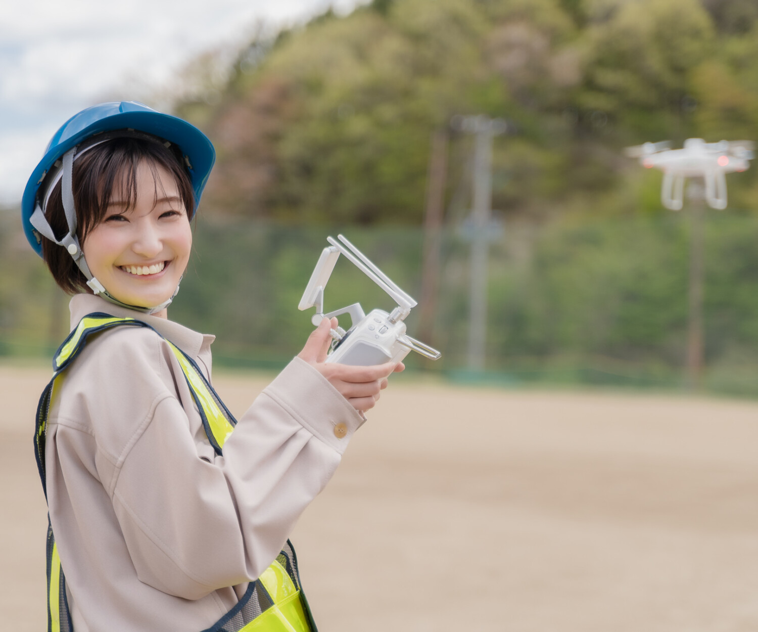 ドローンの操作をして楽しく笑顔な女性の受講者
