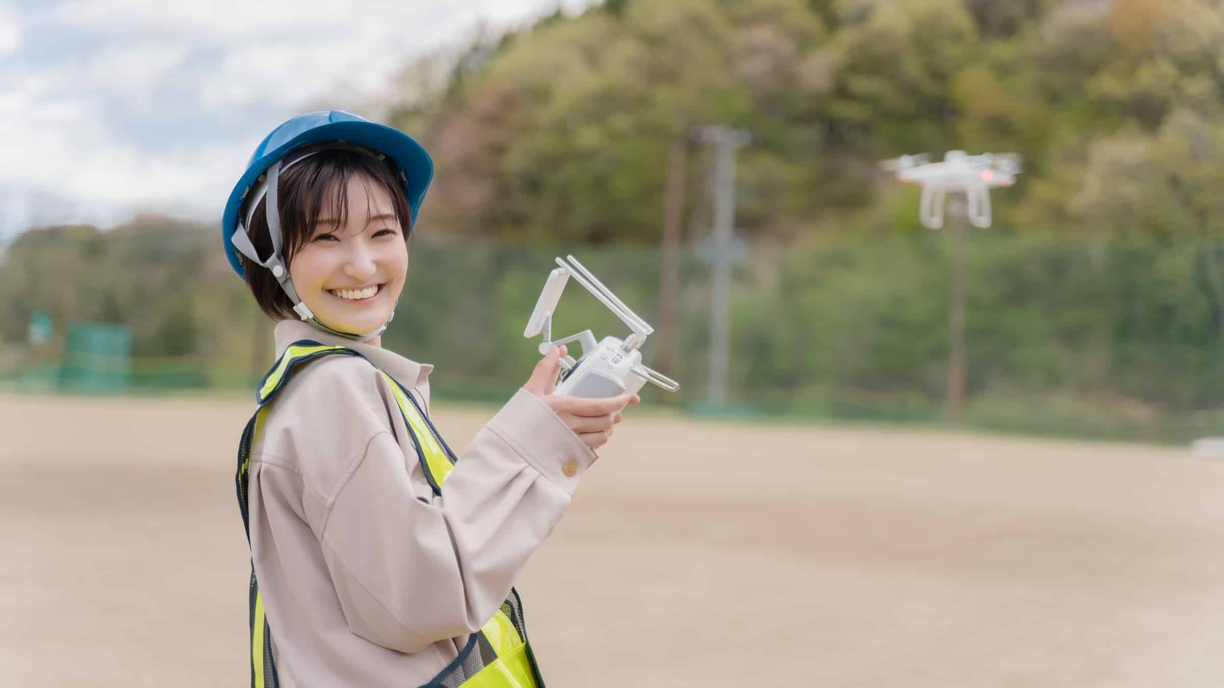 ドローンの操作をして楽しく笑顔な女性の受講者