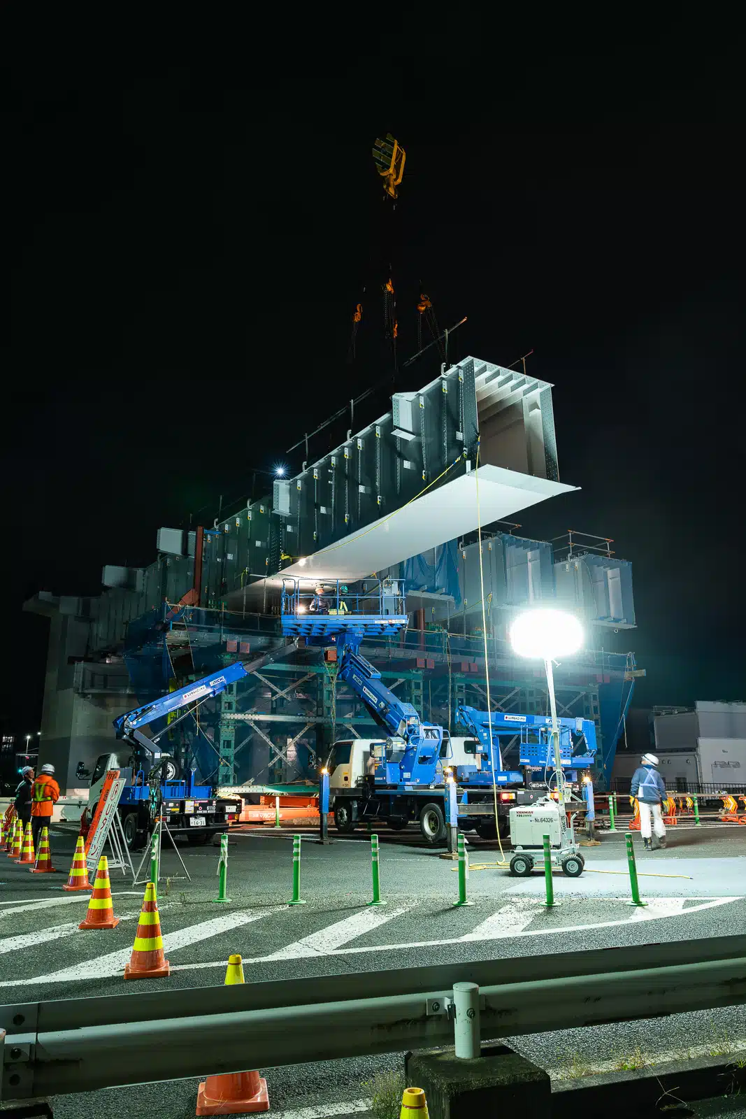 クレーンで釣られた桁ブロック架設作業